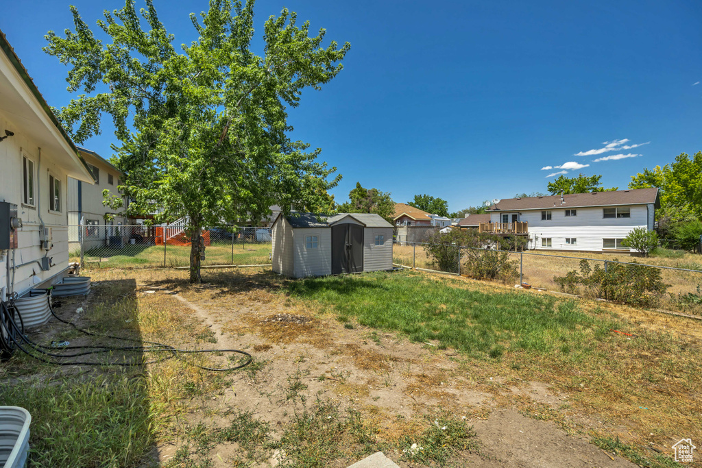 Fenced backyard with a storage unit and a residential view