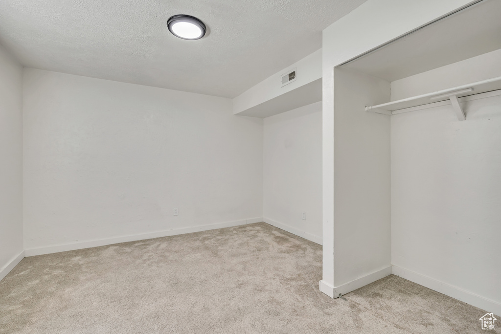 Unfurnished bedroom featuring carpet flooring and a textured ceiling