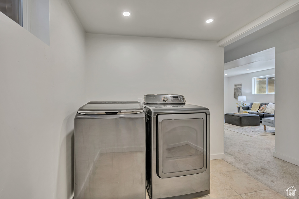 Washroom with independent washer and dryer, light colored carpet, recessed lighting, and light tile patterned floors