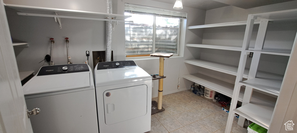 Washroom with separate washer and dryer and light tile patterned flooring