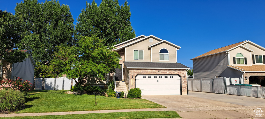 View of front of house with concrete driveway, a garage, and brick siding