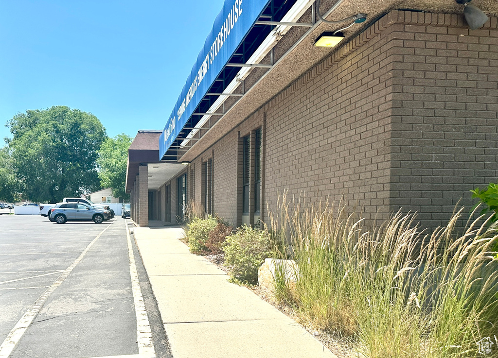 View of side of property with uncovered parking and brick siding