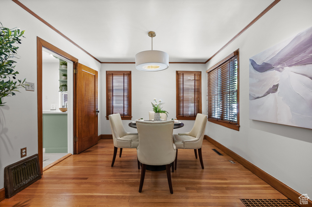 Dining room featuring light wood-style flooring and ornamental molding