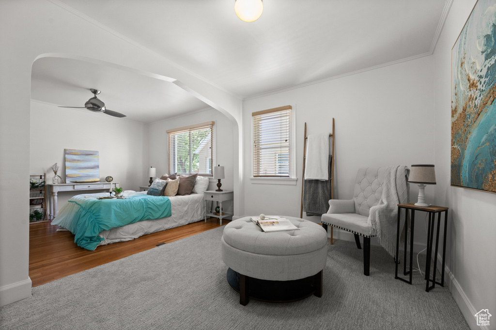 Bedroom with crown molding, a ceiling fan, and wood finished floors