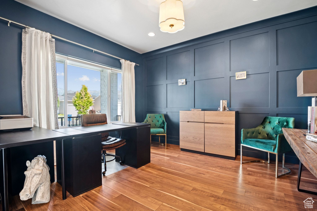 Office space featuring a decorative wall, light wood finished floors, and recessed lighting