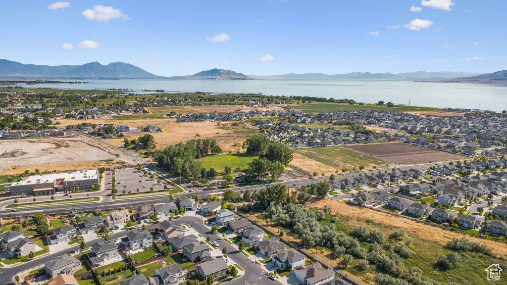 Aerial view of property and surrounding area with a water and mountain view and nearby suburban area