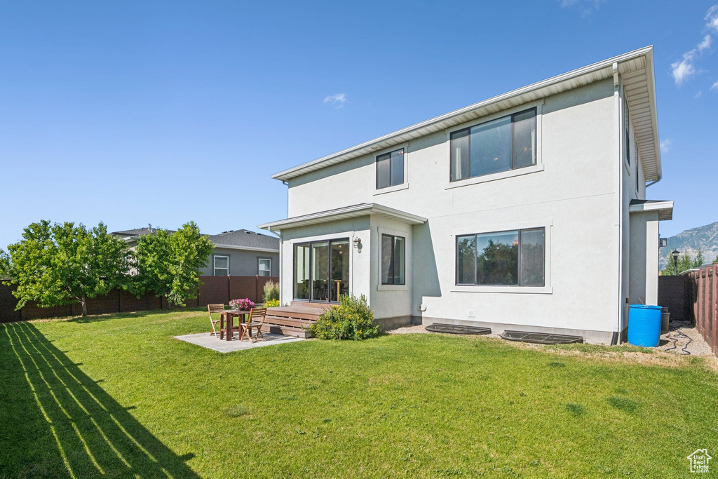 Rear view of property featuring a fenced backyard, stucco siding, and a patio area