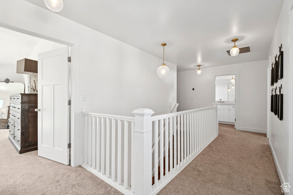 Corridor featuring carpet and an upstairs landing