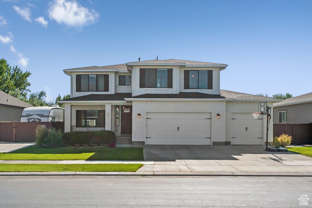 Prairie-style home featuring an attached garage, concrete driveway, and roof with shingles