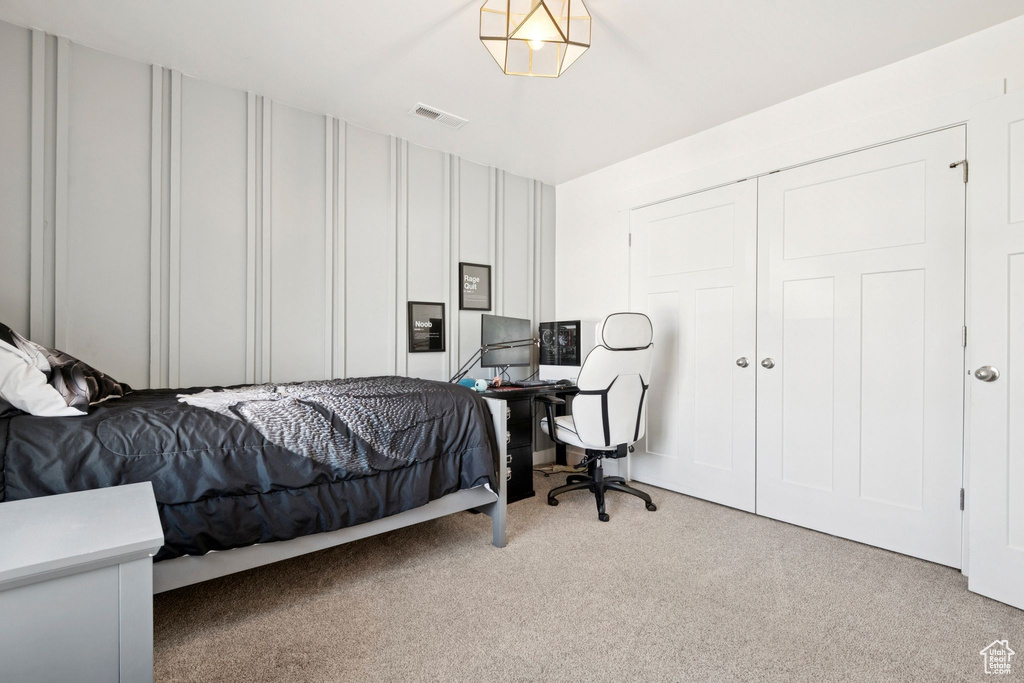 Bedroom with light carpet and a closet