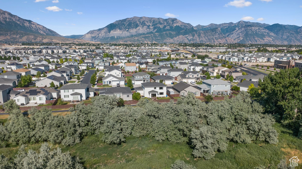 Aerial view of property and surrounding area featuring a mountain backdrop and nearby suburban area