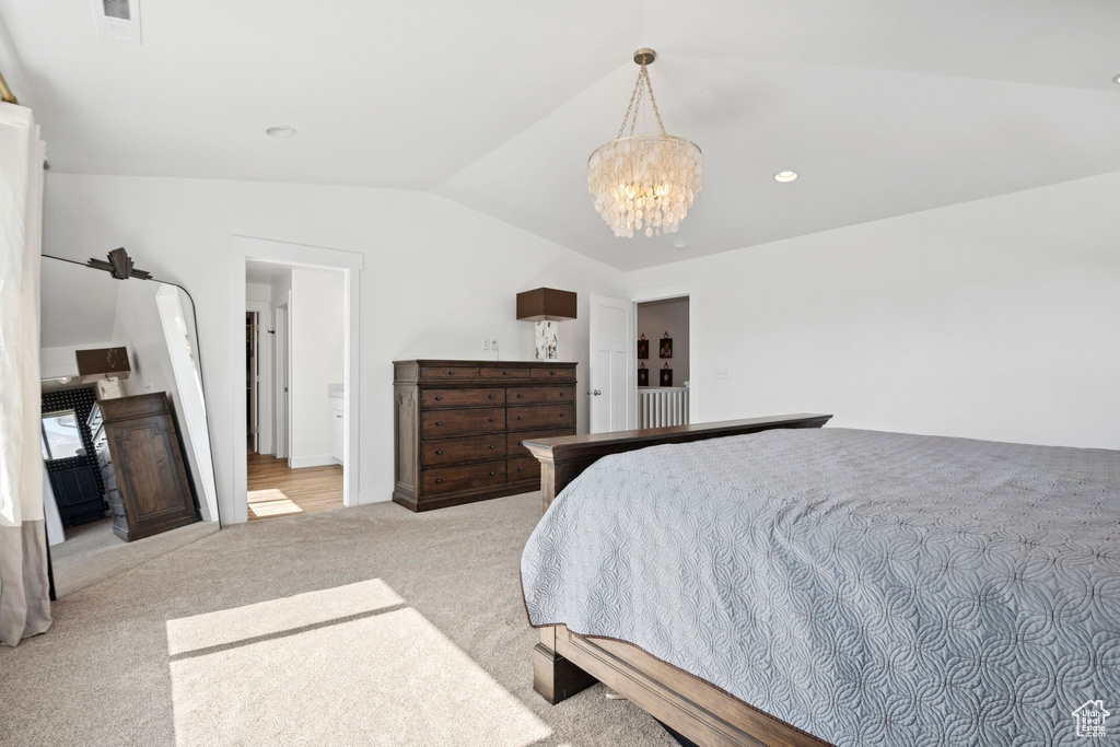 Bedroom featuring vaulted ceiling, light carpet, and a chandelier