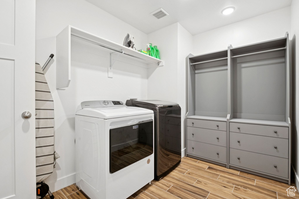 Washroom featuring independent washer and dryer and light wood-style floors