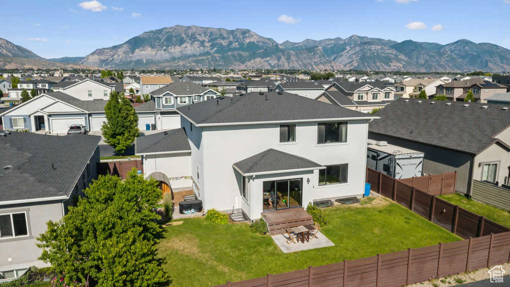 Back of property featuring a residential view, a mountain view, a fenced backyard, and stucco siding