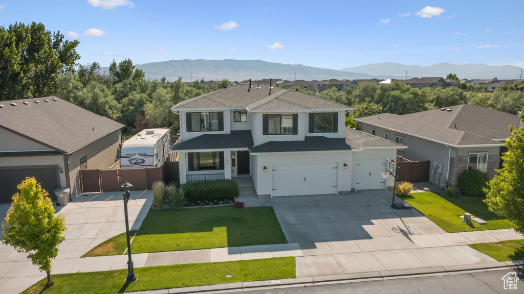 Traditional-style home with a gate, roof with shingles, concrete driveway, and a mountain view