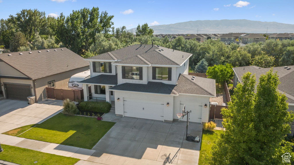 Traditional-style house featuring driveway, a shingled roof, a mountain view, stucco siding, and a gate