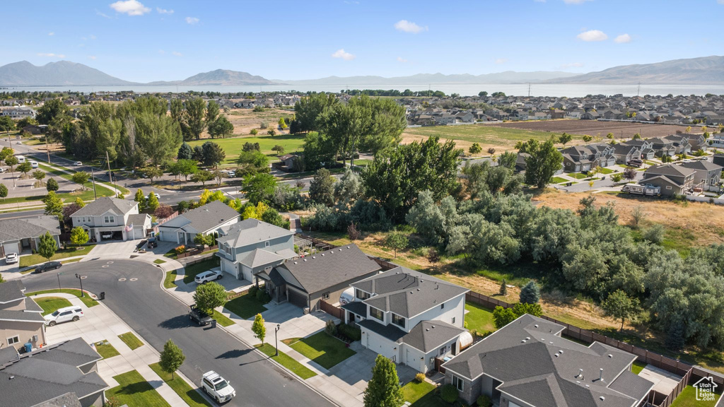 Aerial view of property's location with nearby suburban area and a mountainous background