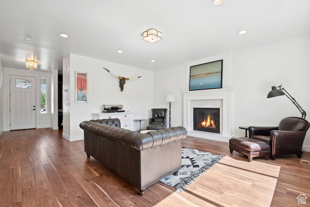 Living area with hardwood / wood-style floors, a premium fireplace, and recessed lighting