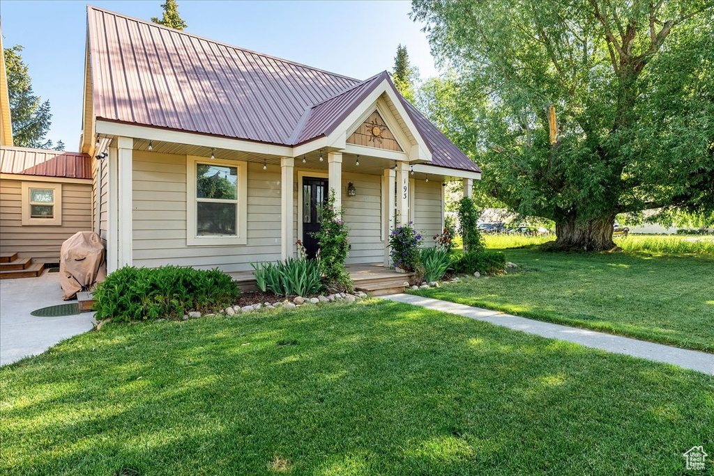 View of front of house featuring a front yard and a metal roof