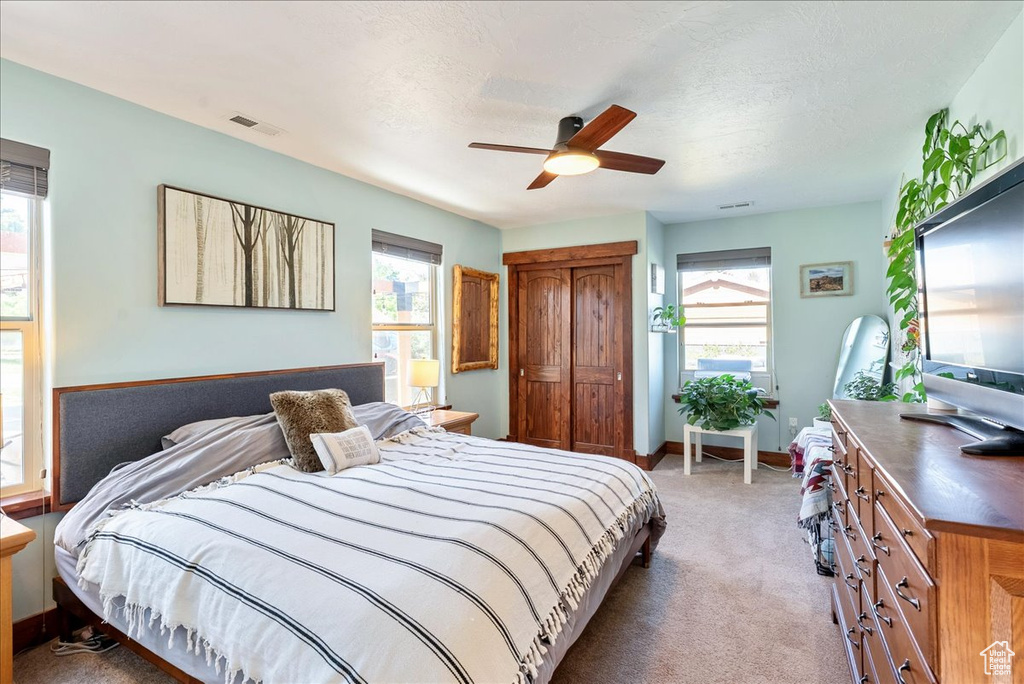 Bedroom with light colored carpet and ceiling fan