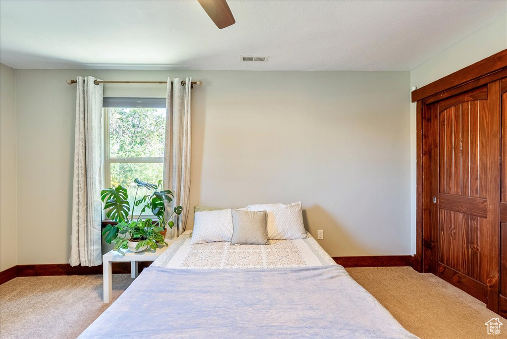 Bedroom featuring light colored carpet and a ceiling fan