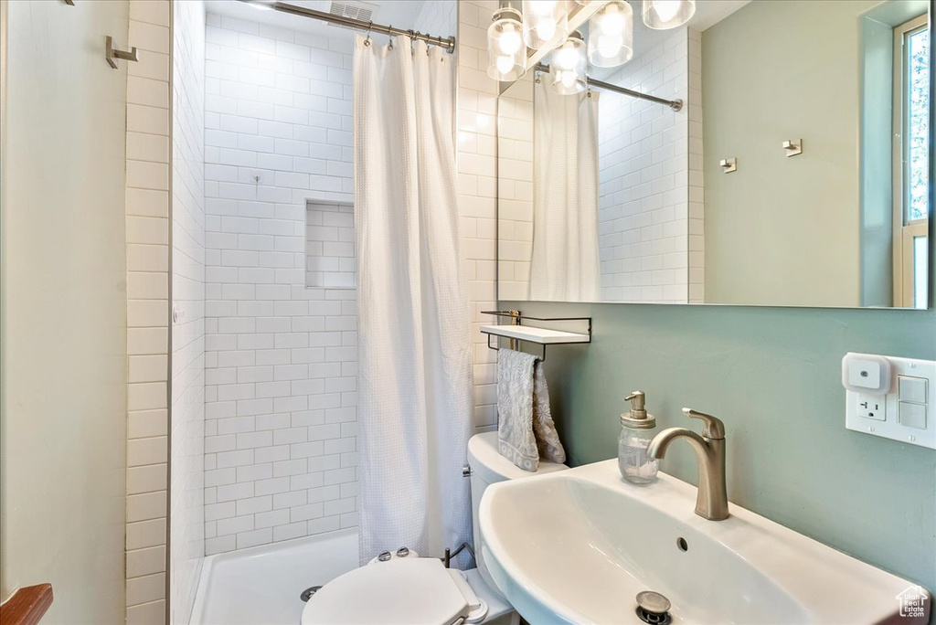 Bathroom featuring a chandelier and a stall shower