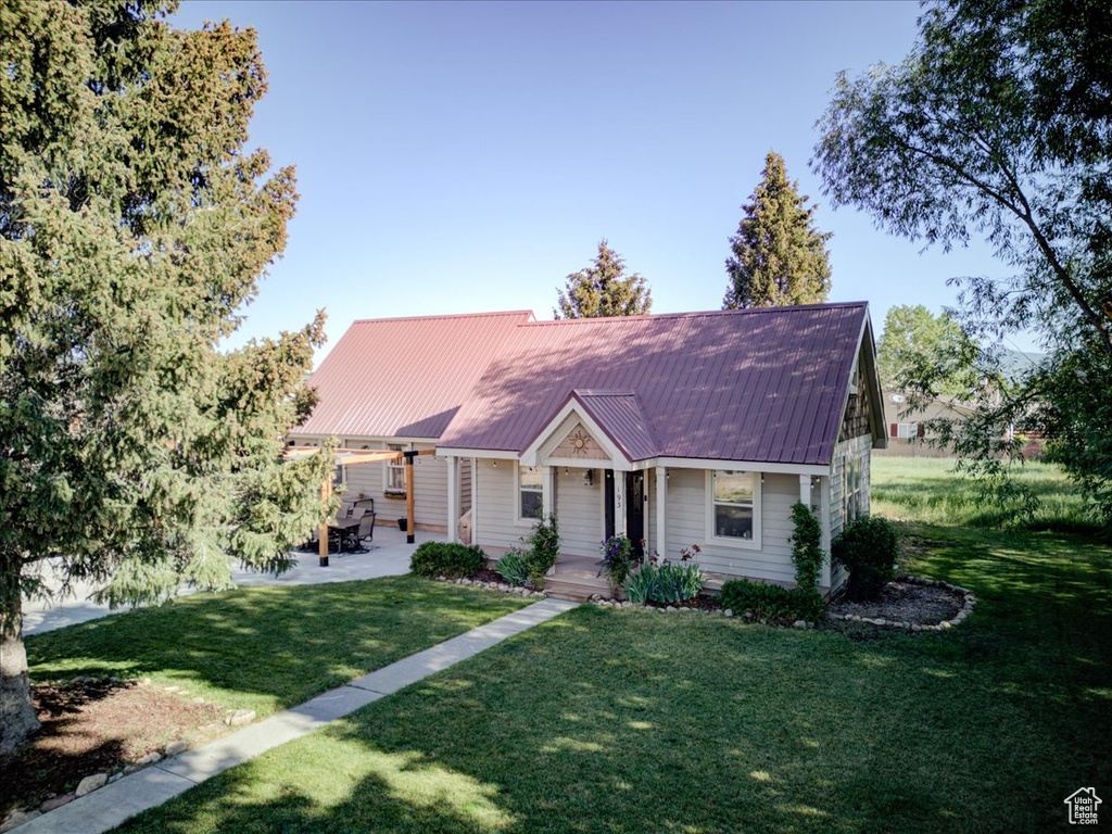 View of front facade with a front lawn and a metal roof