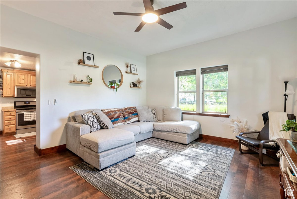 Living room featuring ceiling fan and dark wood finished floors