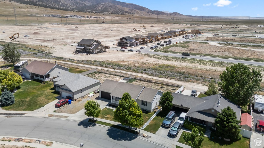 Aerial view of sparsely populated area featuring a mountainous background and nearby suburban area