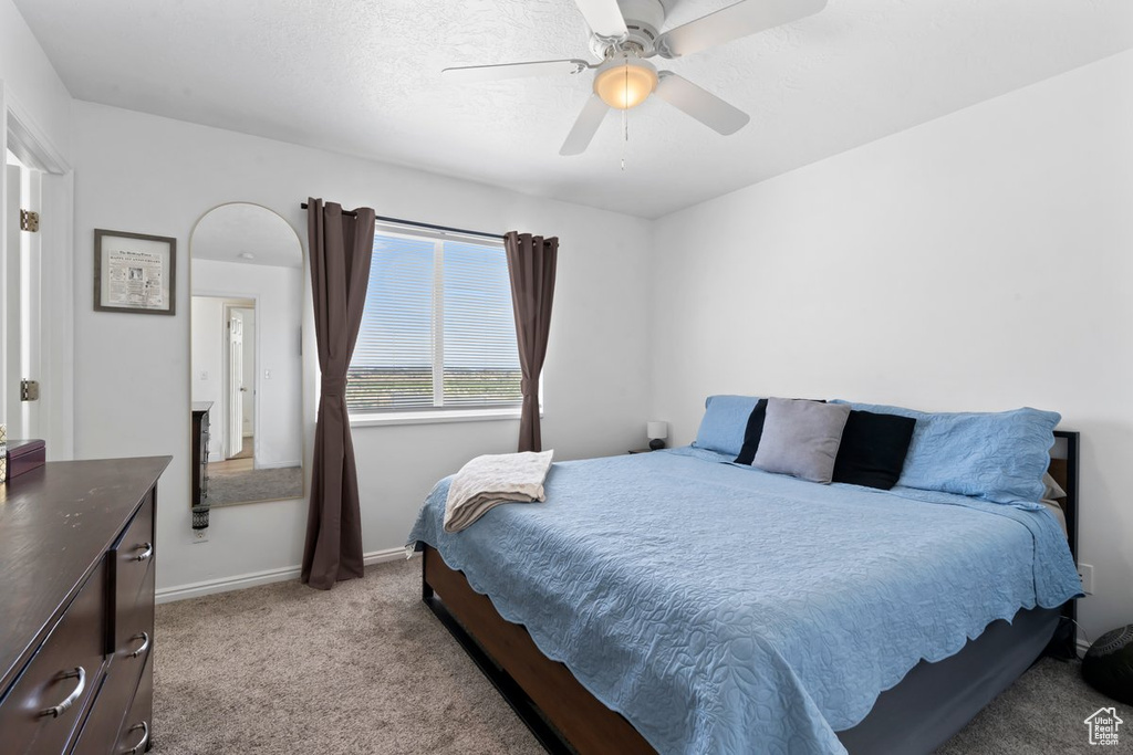 Bedroom with light colored carpet and ceiling fan