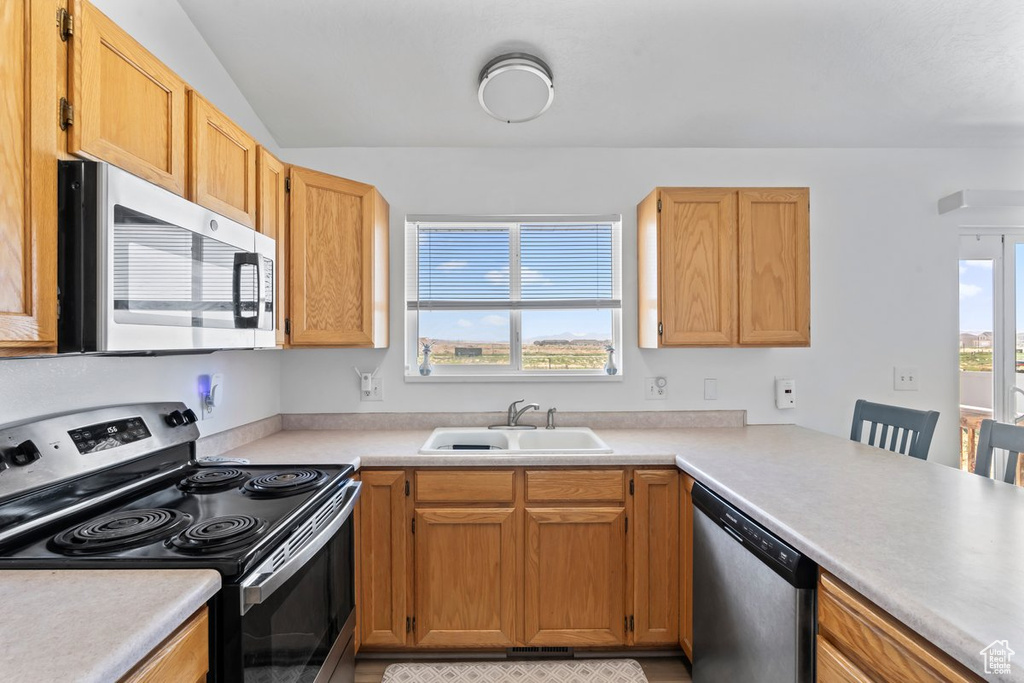 Kitchen featuring appliances with stainless steel finishes and light countertops