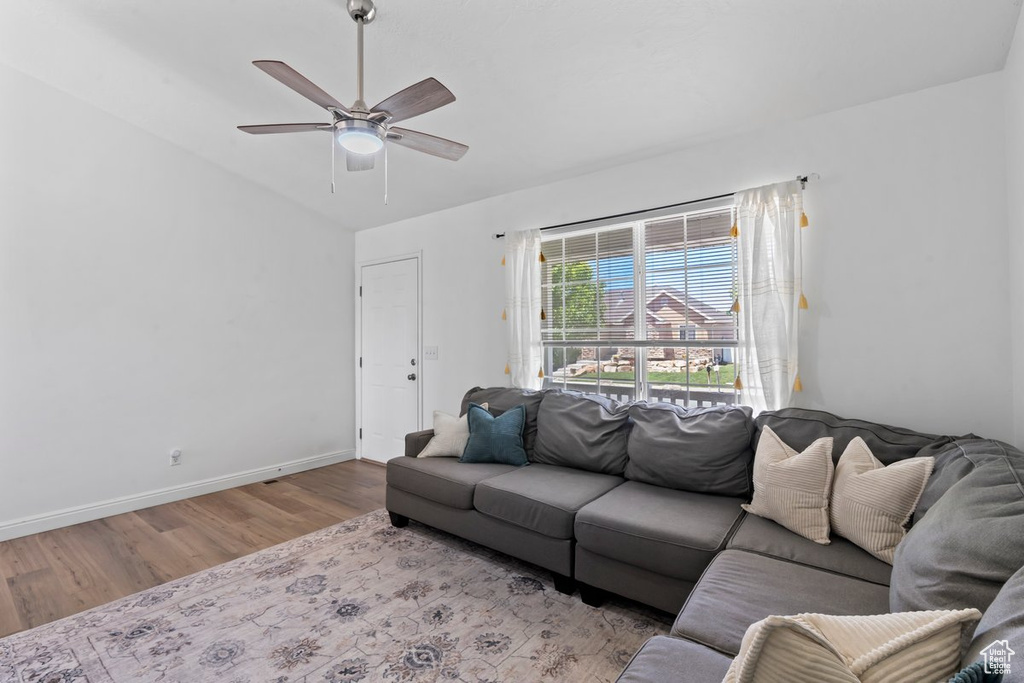 Living area featuring wood finished floors, ceiling fan, and lofted ceiling