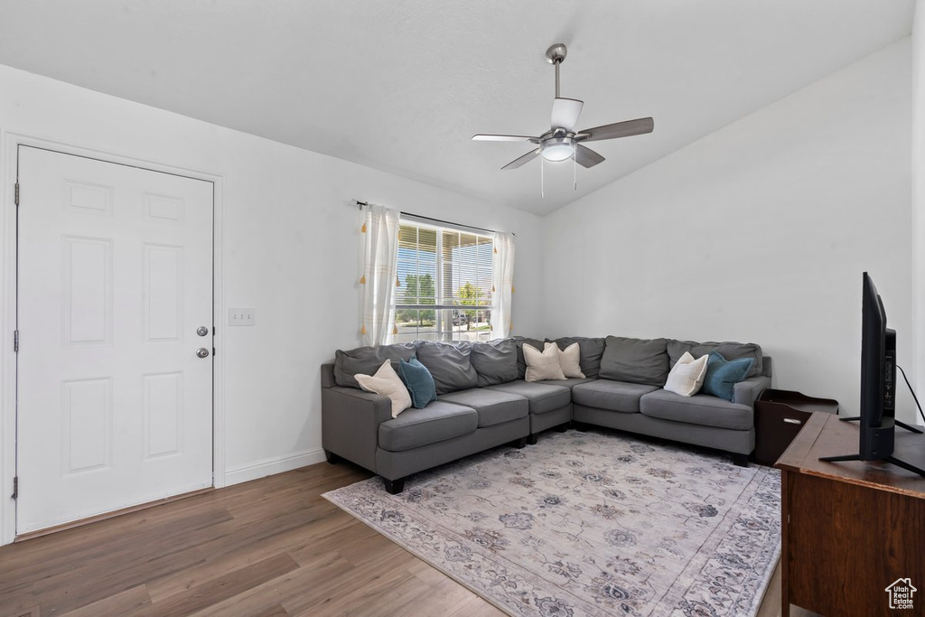 Living room featuring wood finished floors, ceiling fan, and lofted ceiling