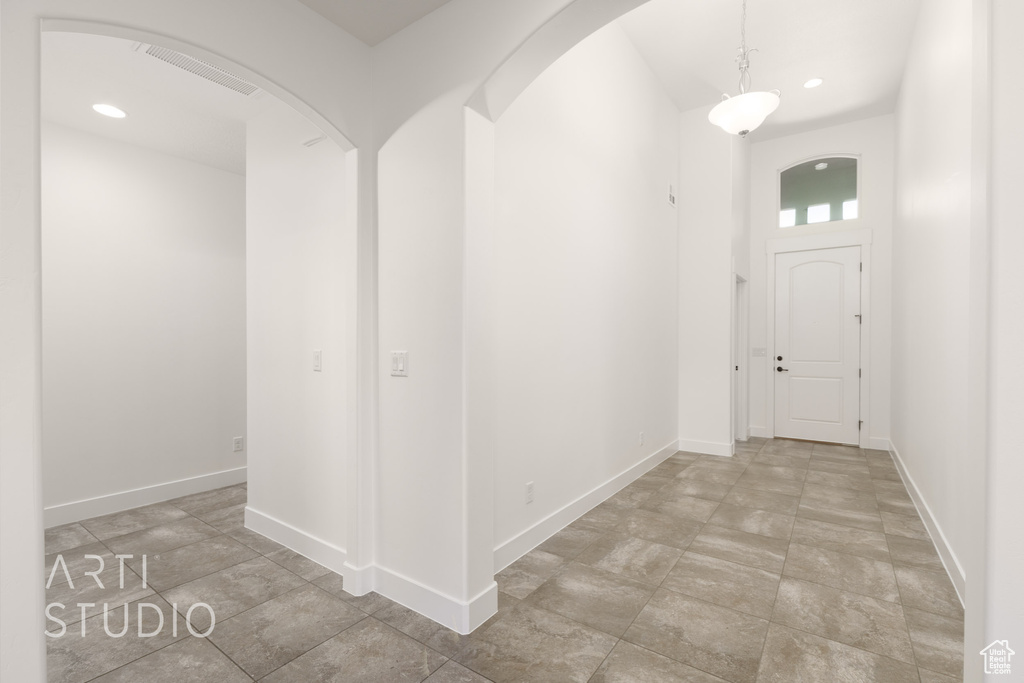 Hallway with recessed lighting and arched walkways