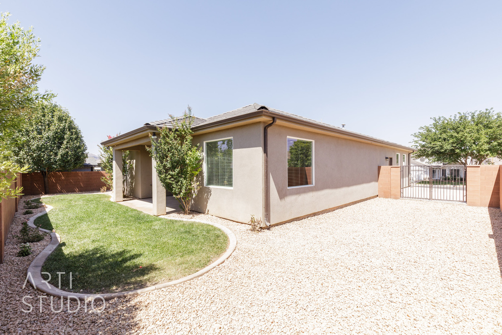 View of side of property with a fenced backyard, stucco siding, a gate, and a patio area