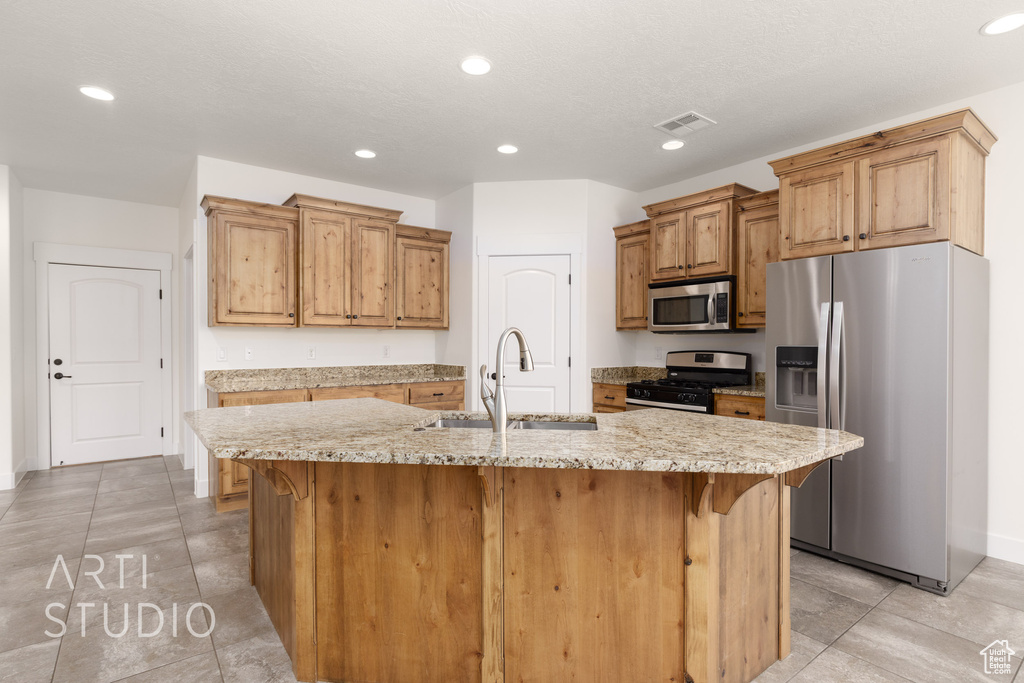 Kitchen with appliances with stainless steel finishes, a kitchen breakfast bar, recessed lighting, a center island with sink, and light tile patterned floors