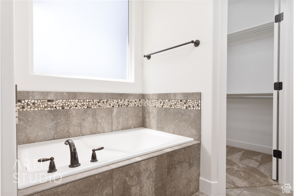 Bathroom with a garden tub and a spacious closet