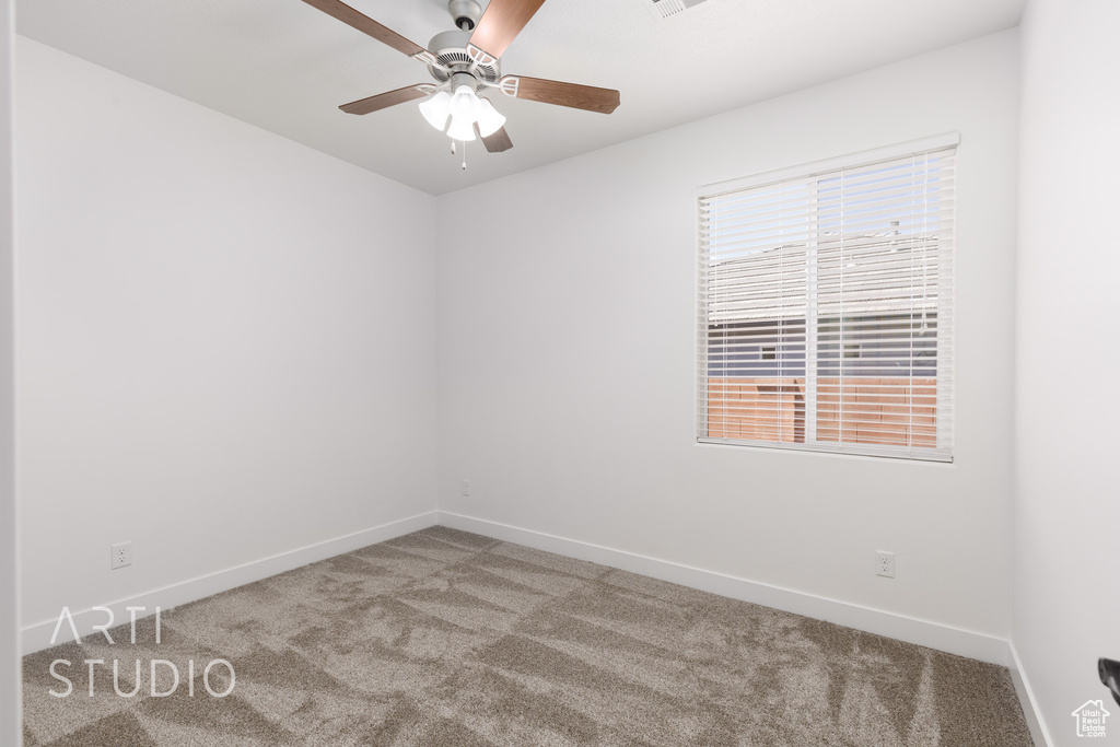 Carpeted empty room with baseboards and a ceiling fan