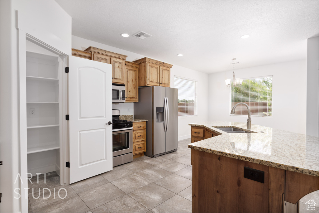 Kitchen with appliances with stainless steel finishes, a chandelier, plenty of natural light, decorative light fixtures, and recessed lighting