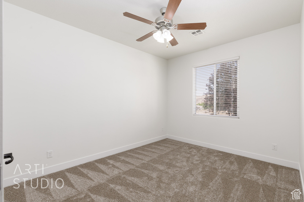 Empty room featuring carpet flooring and ceiling fan
