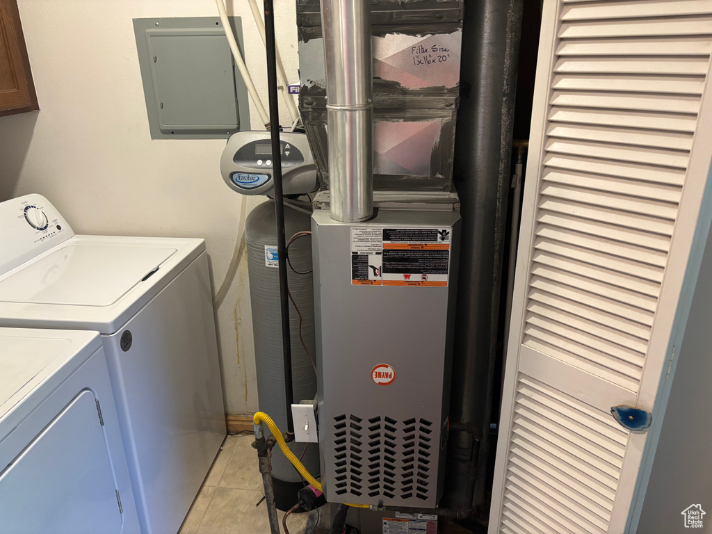 Laundry area featuring separate washer and dryer, electric panel, and light tile patterned floors