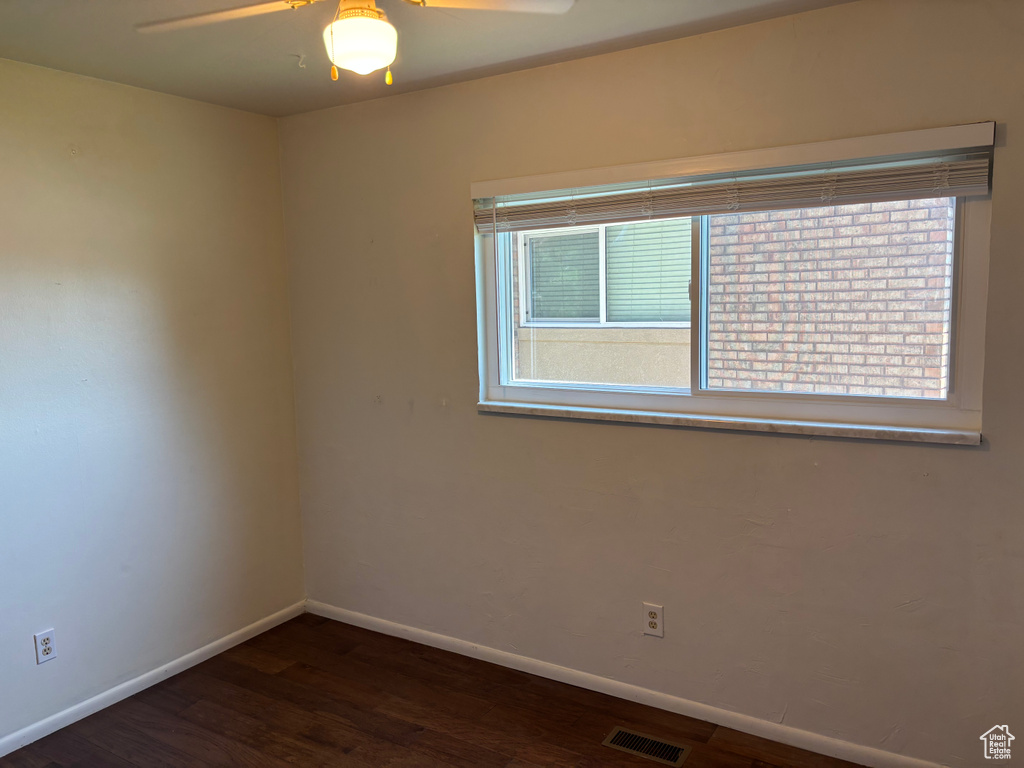 Spare room featuring plenty of natural light, ceiling fan, and wood finished floors