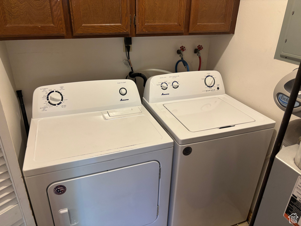 Laundry room with cabinet space, washer and dryer, and electric panel
