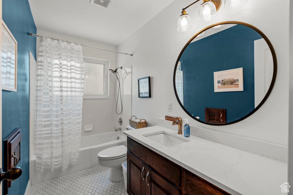 Bathroom with shower / bathtub combination with curtain, vanity, and tile patterned floors