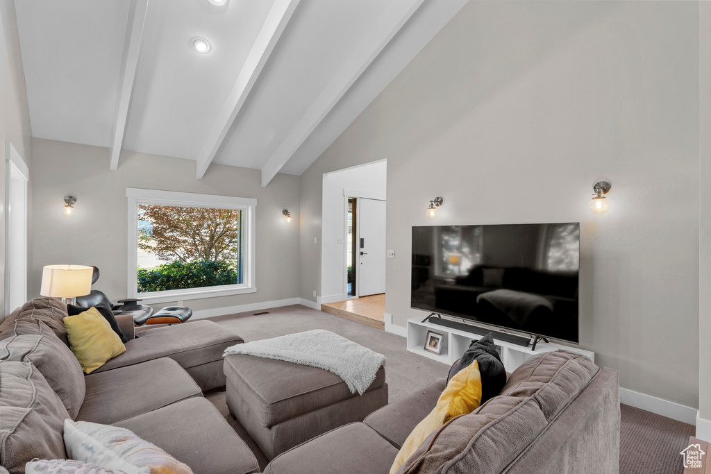 Living room featuring carpet, beam ceiling, and high vaulted ceiling