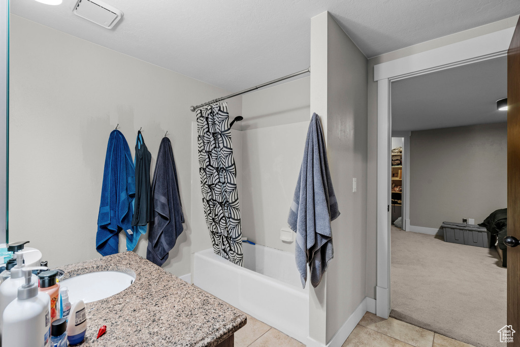 Bathroom featuring vanity, shower / bath combo, and tile patterned floors