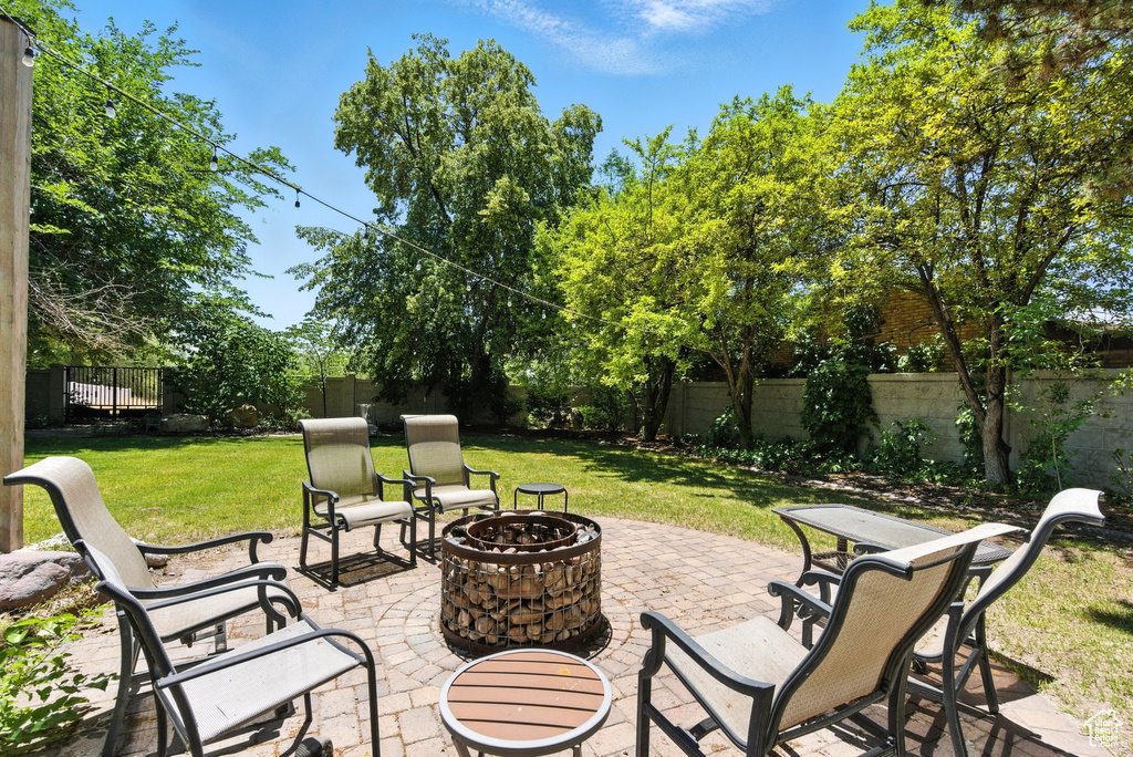 Fenced backyard featuring a fire pit and a patio area