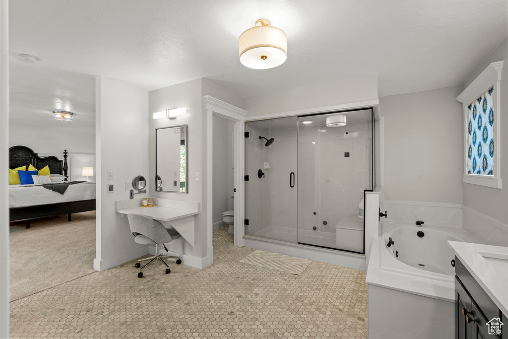 Ensuite bathroom featuring a shower stall, a jetted tub, tile patterned flooring, and vanity