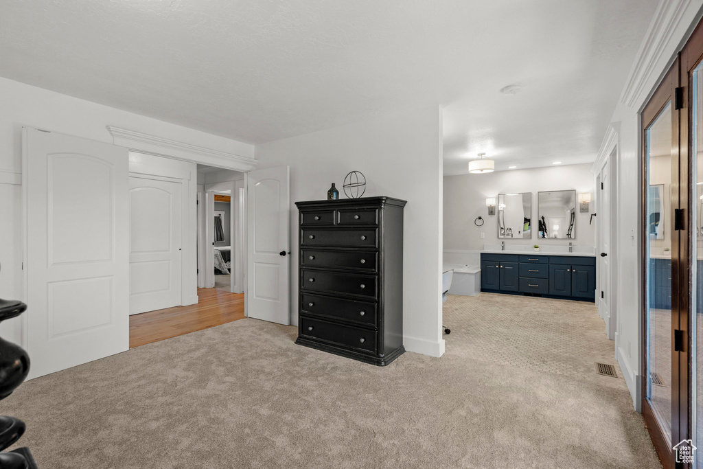Bedroom featuring light carpet and connected bathroom