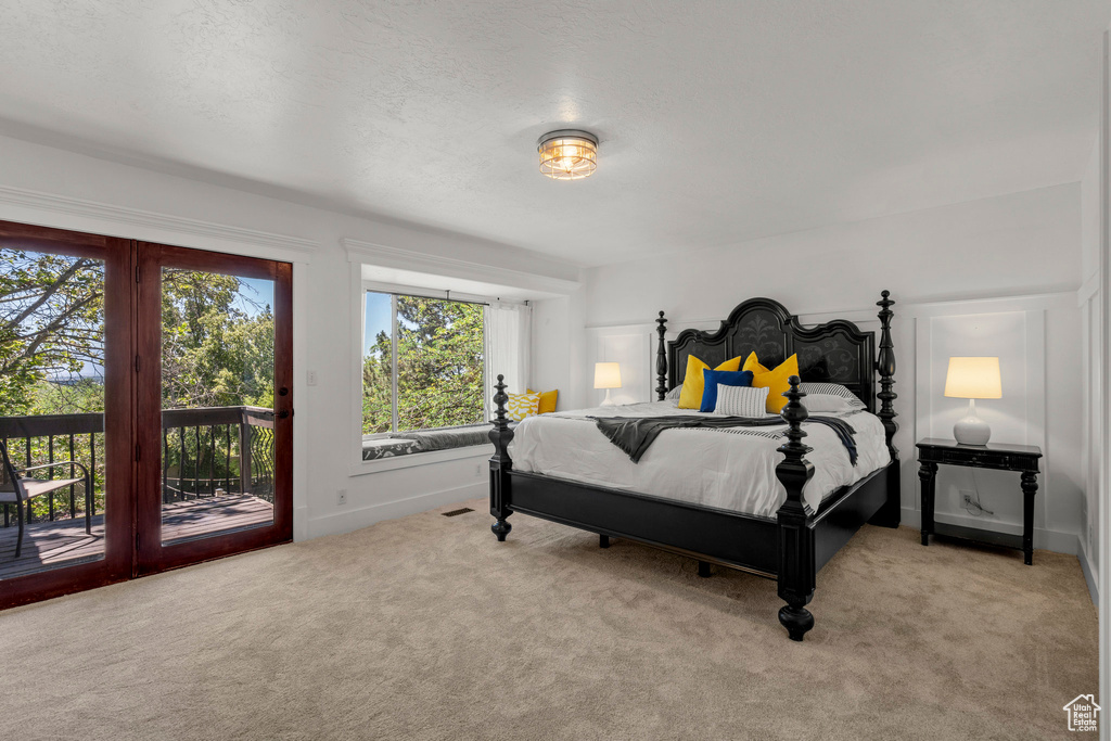 Bedroom with access to exterior and carpet floors